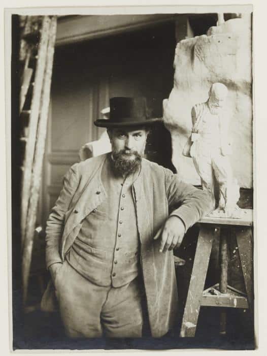 Antoine Bourdelle standing beside his self-portrait in the studio, circa 1908
